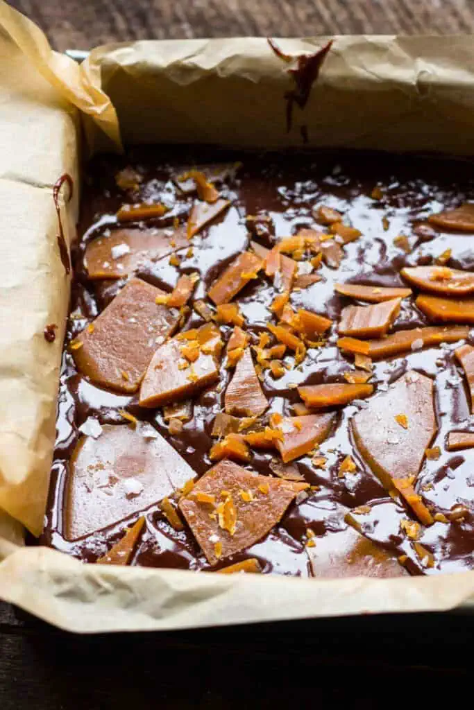 pan of raw brownie batter with pieces of caramel on top