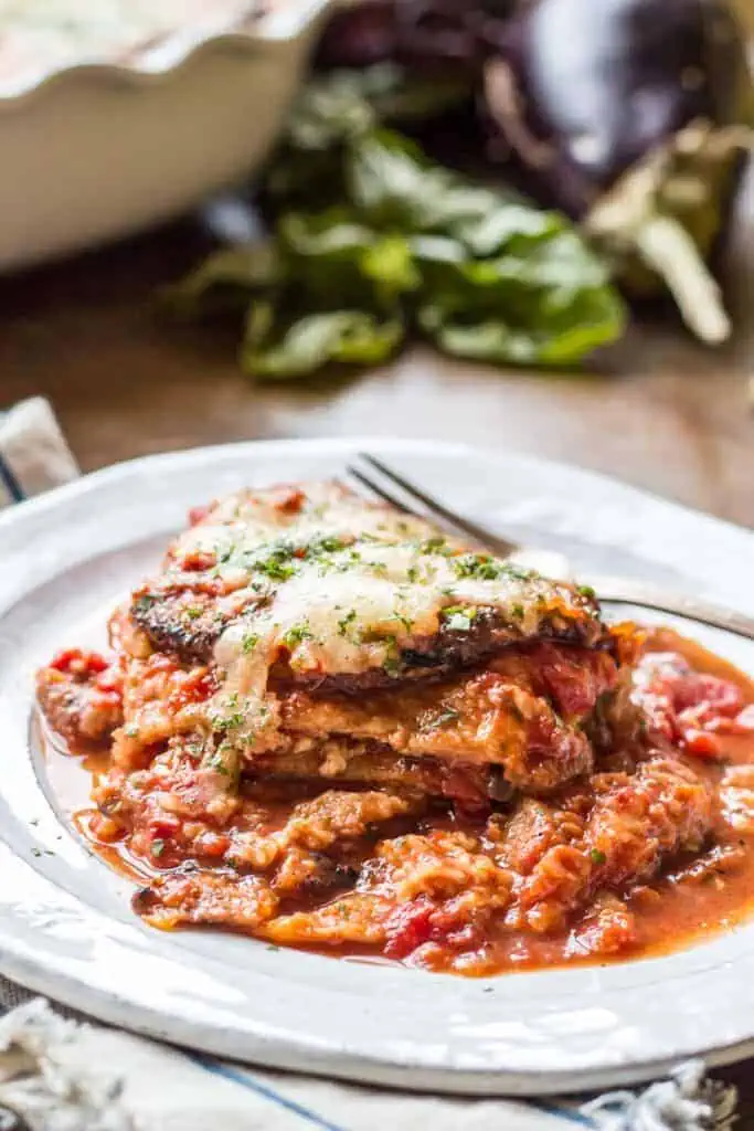 Close up of saucy eggplant parmesan with a fork.