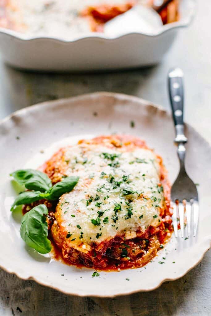 A serving of eggplant parmesan with a fork.