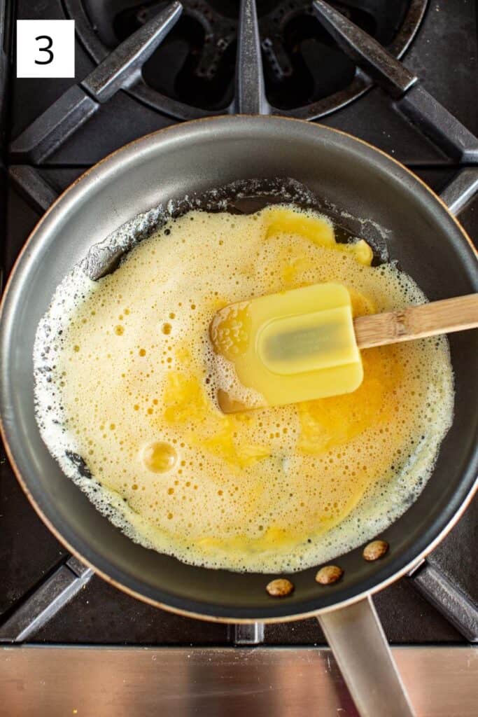 overhead shot of a spatula mixing eggs in a pan