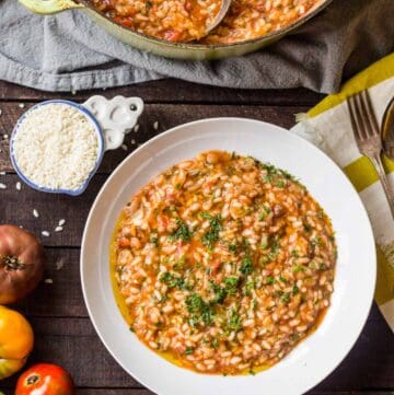 Top view of tomato fennel risotto in a white bowl.
