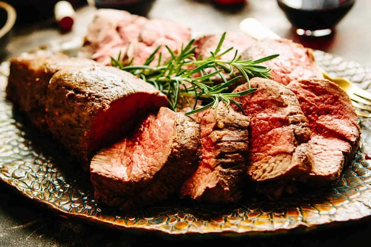 Close up of sliced beef tenderloin on a platter.