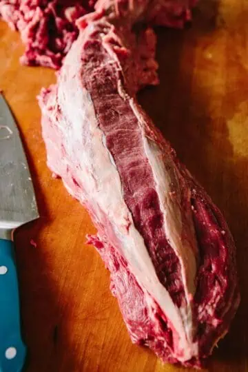 A raw beef tenderloin with silver skin removed.