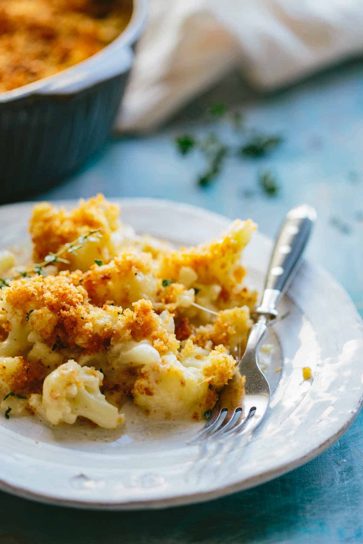Side view of a plate of cauliflower gratin with a fork.