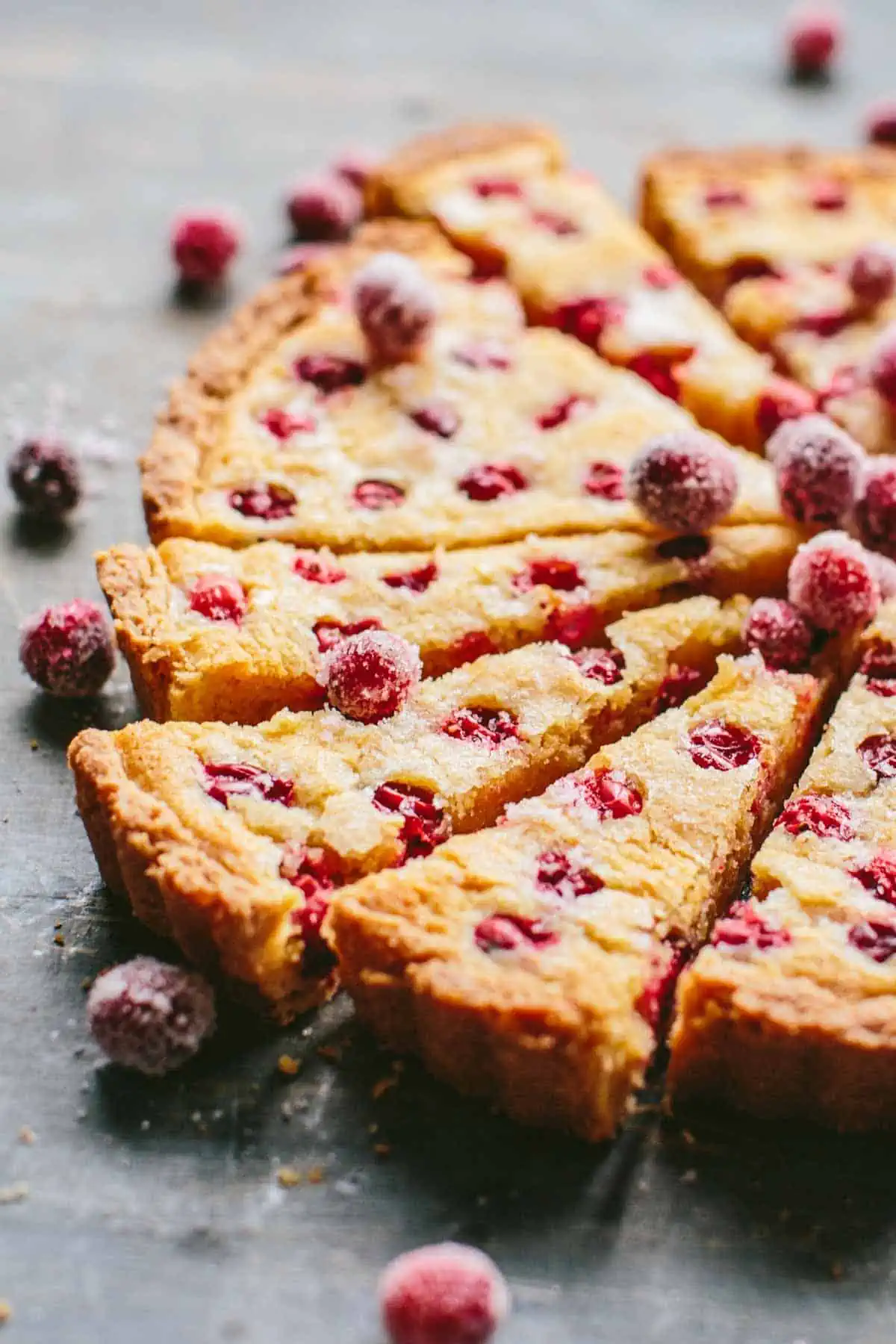 Close up side view of several slices of a cranberry frangipane tart.