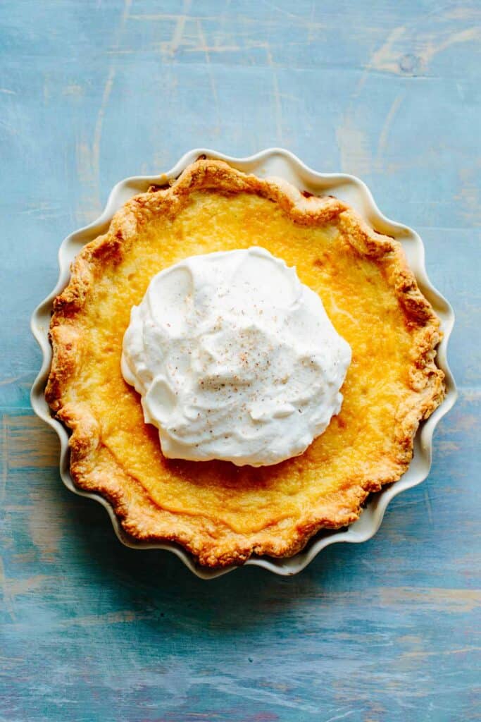 Top view of a pie with a big pile of whipped cream in the center.