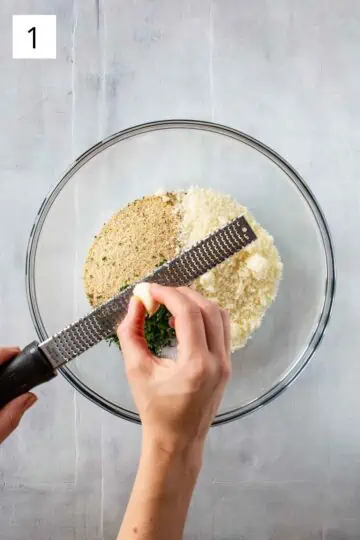 Grating garlic into bowl of ingredients.
