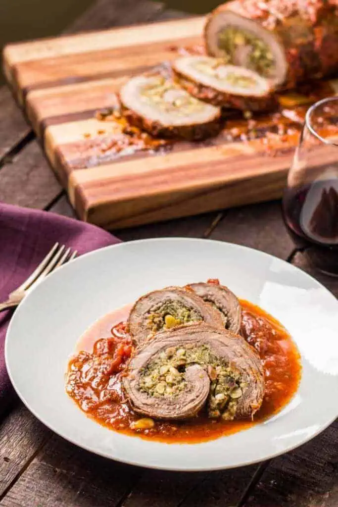 A white plate with pinwheels of authentic Italian beef braciole.