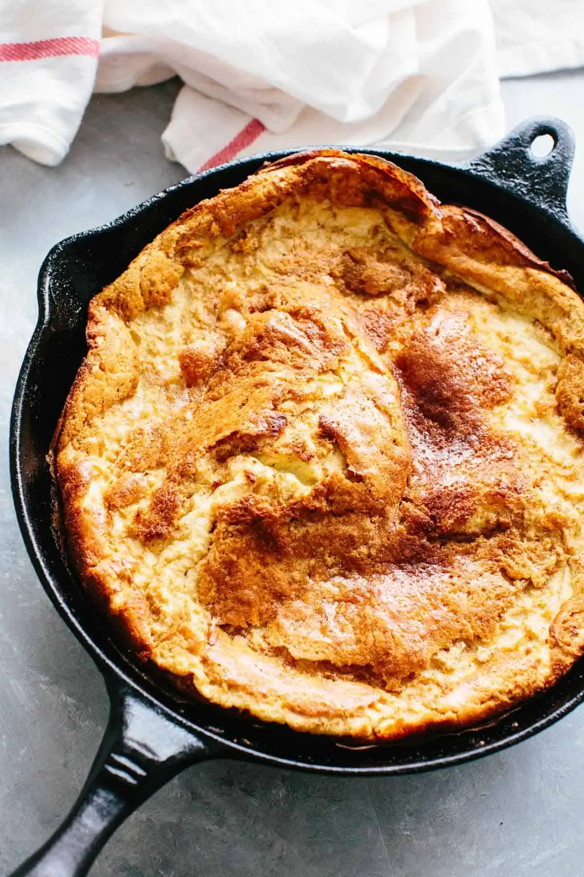 A close up of a Dutch baby pancake in a cast iron skillet.