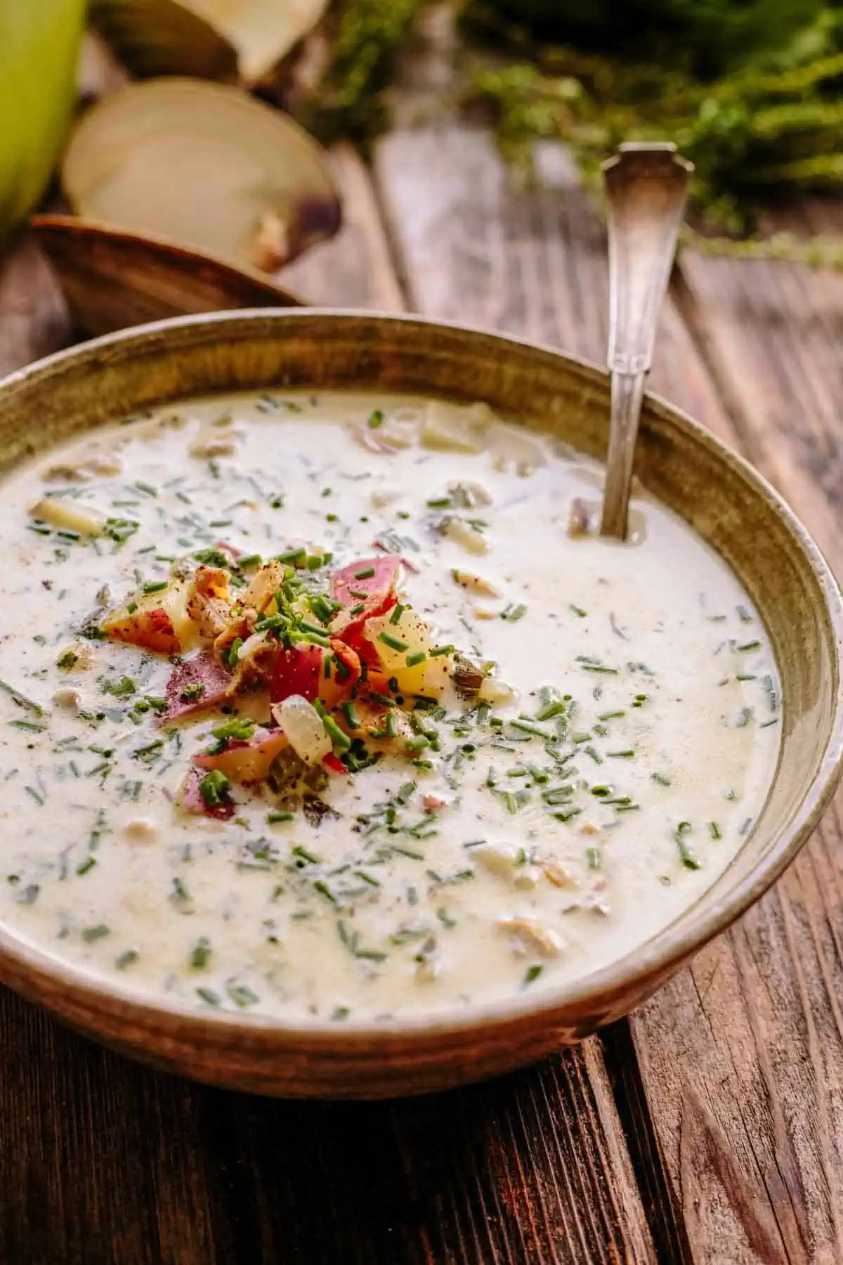 Close up of a bowl of 5 star New England clam chowder with a spoon.