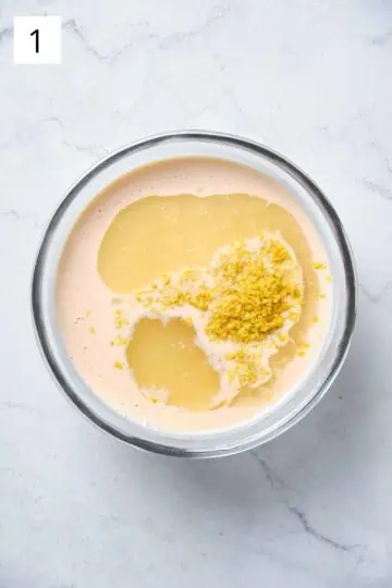 A bowl with heavy cream, sugar, lemon juice and lemon zest.