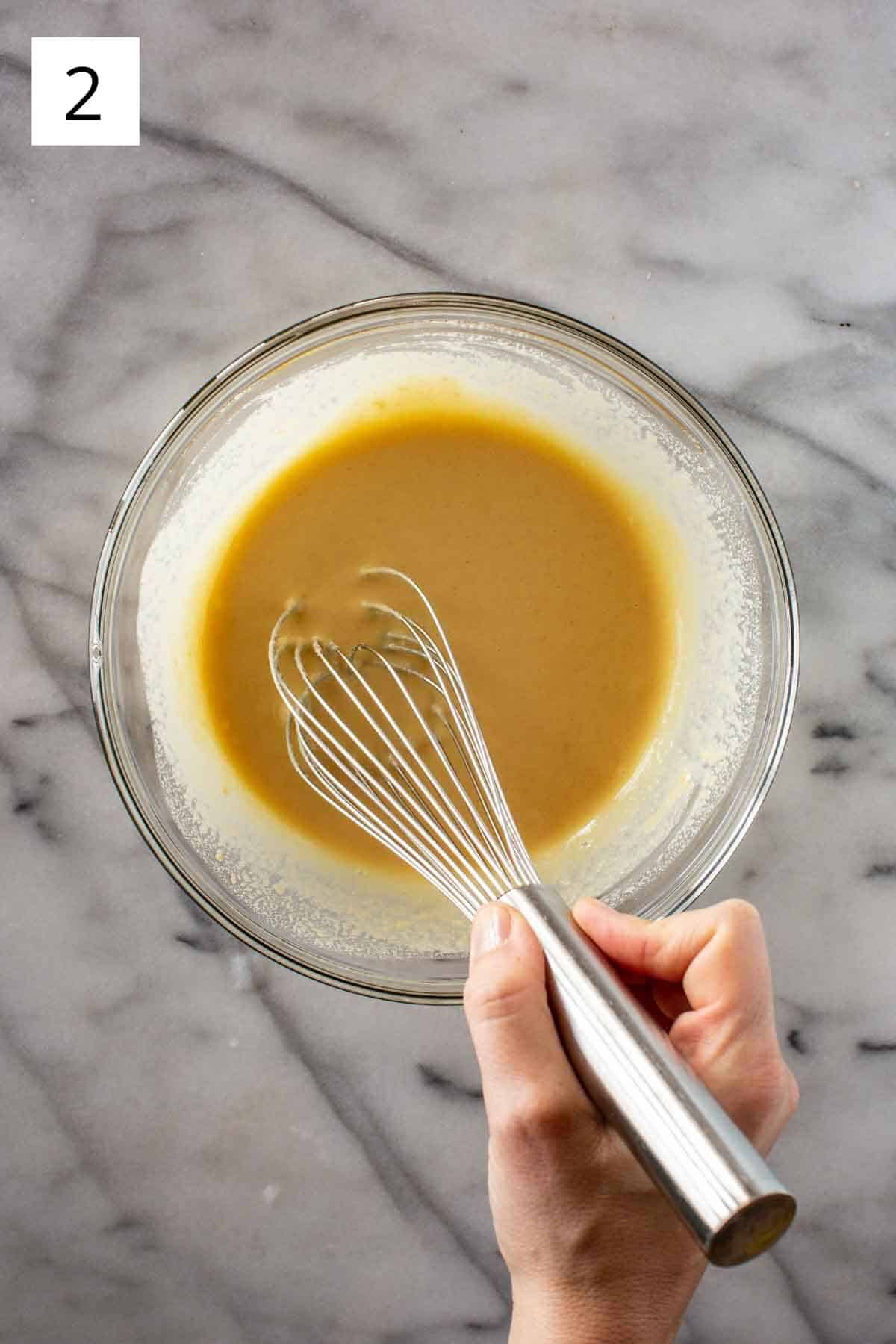 A bowl of chickpea batter with a whisk.