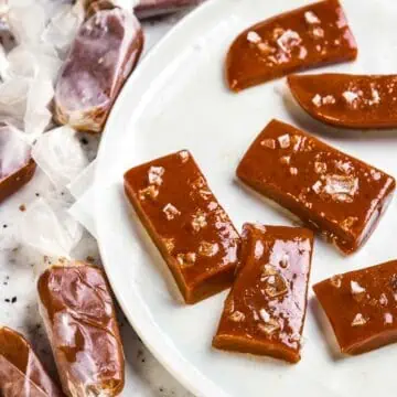A plate of caramel candies with sea salt on a white plate.