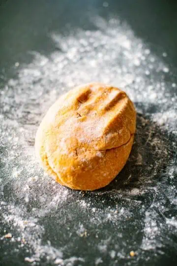 Ball of sweet potato gnocchi dough on a floured surface.