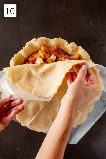 Laying the top crust over a filled pie. 