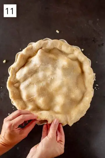 Pinching together the top and bottom crusts of a filled pie before baking. 