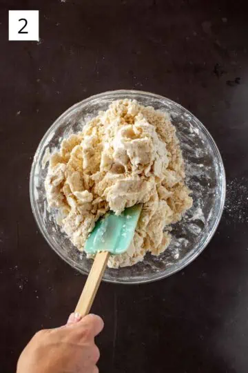 Mixing water into pie dough ingredients with a rubber spatula. 