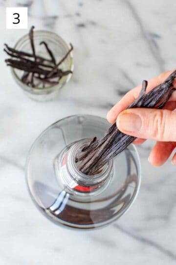 Stuffing a bundle of vanilla beans into a bottle of vodka.