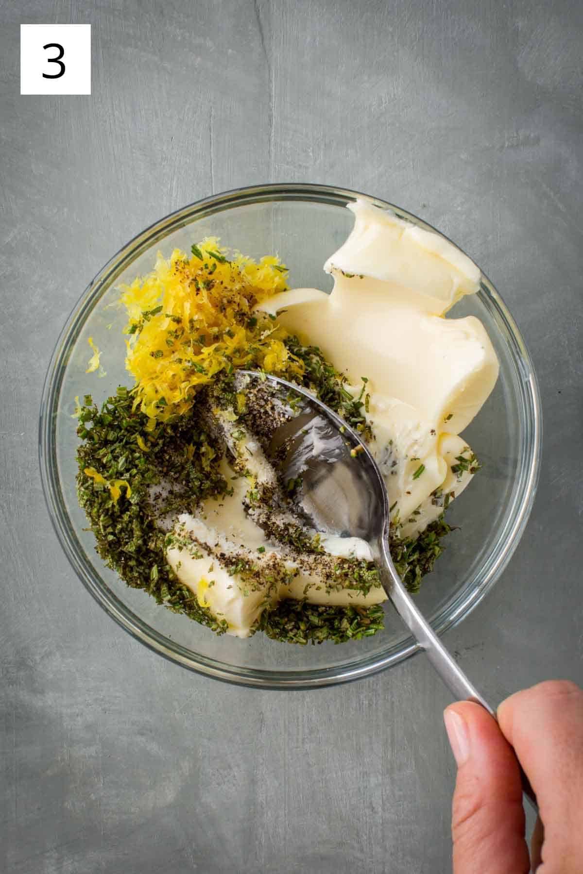 Combining herb butter mixture ingredients in a bowl.