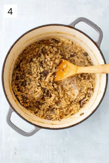 Creamy mushroom risotto cooking in a large pot. 