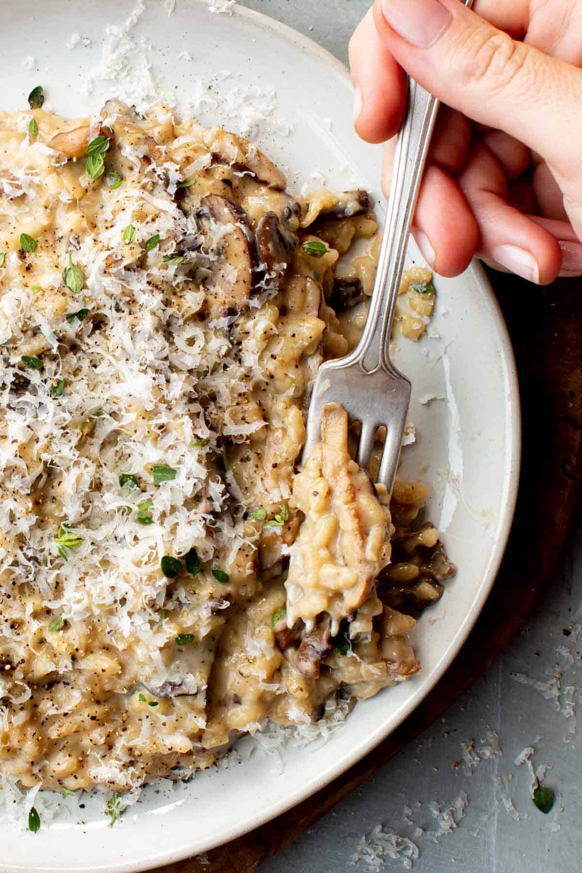 A bite of creamy mushroom risotto on a fork. 