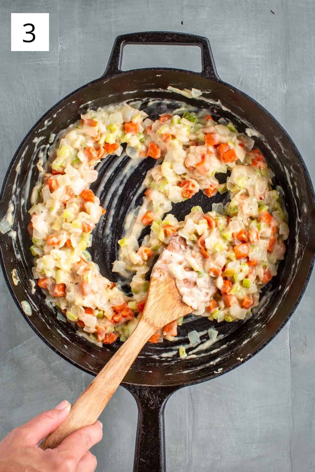 Stirring turkey stock into vegetable mixture.