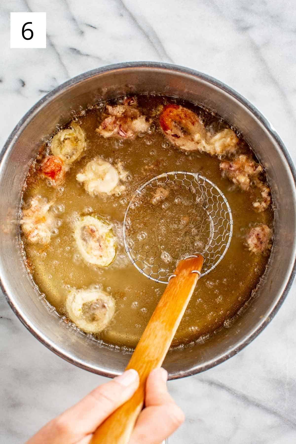 Frying calamari in a large pot of oil.