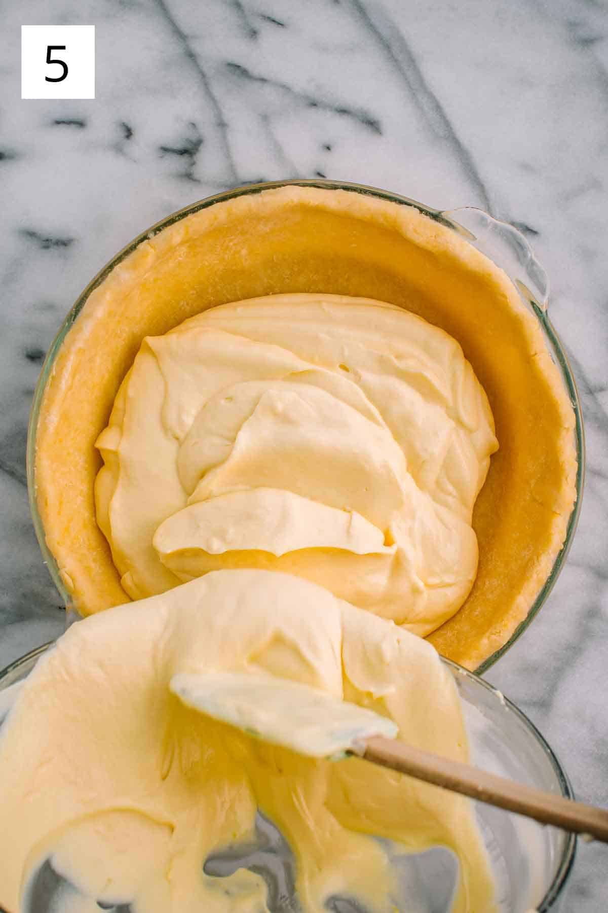 Creamy ricotta filling being poured into pie crust.