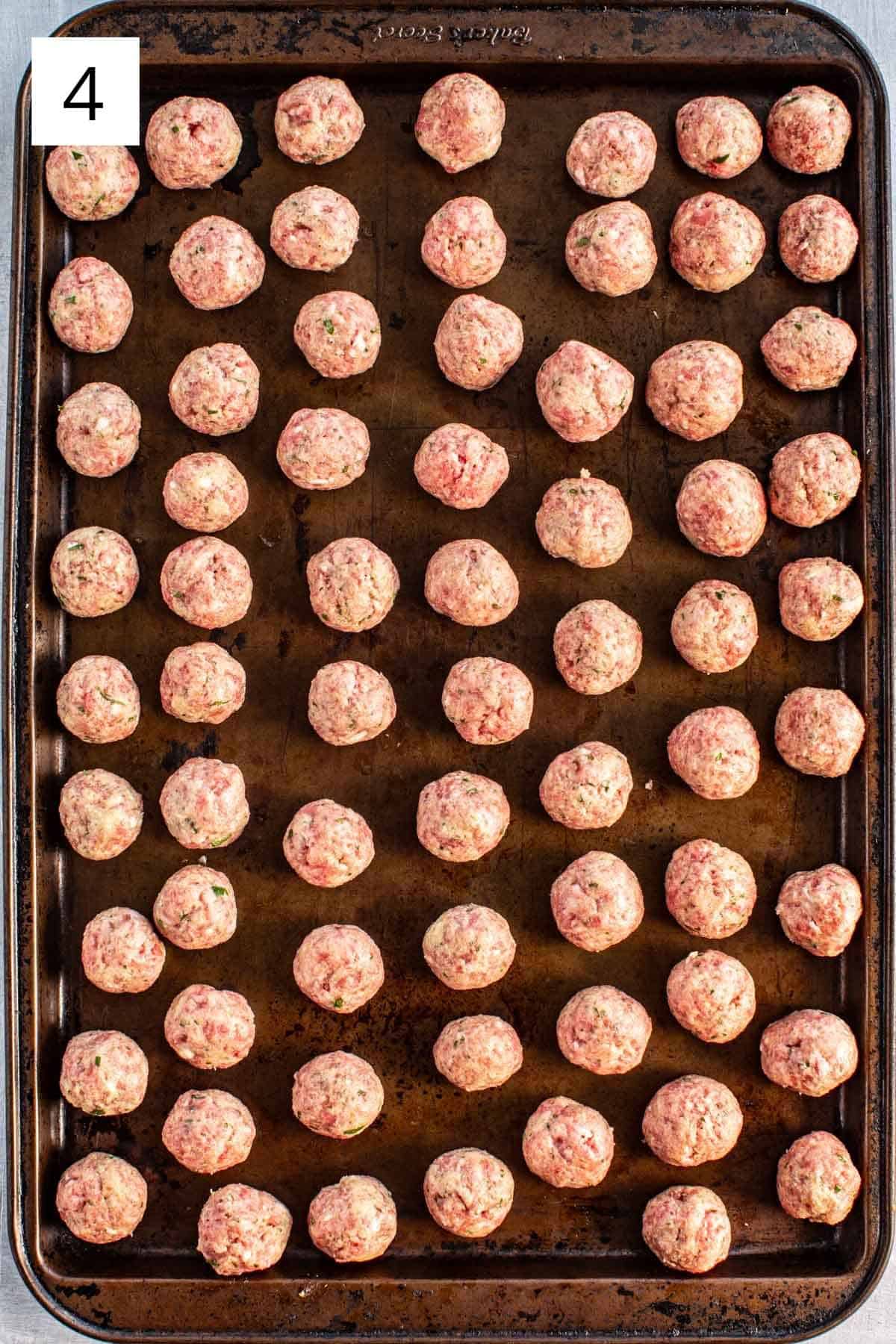 Small Italian meatballs on a baking sheet.