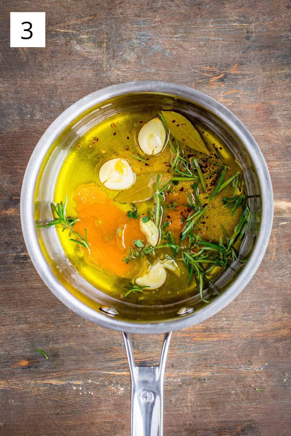 A small saucepan filled with ingredients for marinated olives.