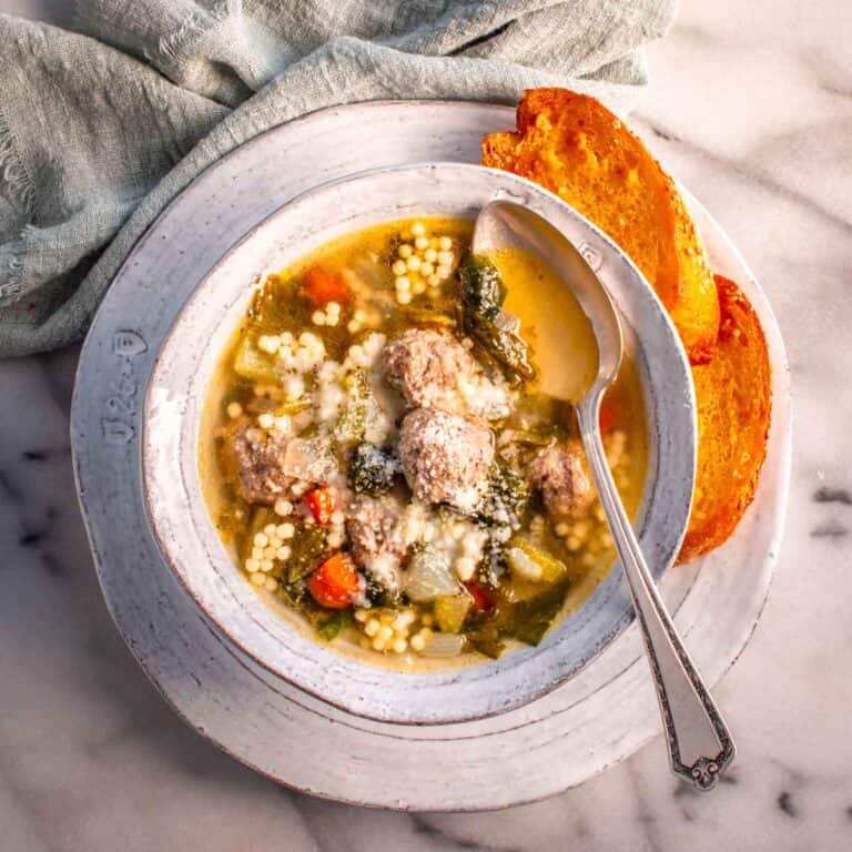 Bowl of cheese topped Italian wedding soup. 