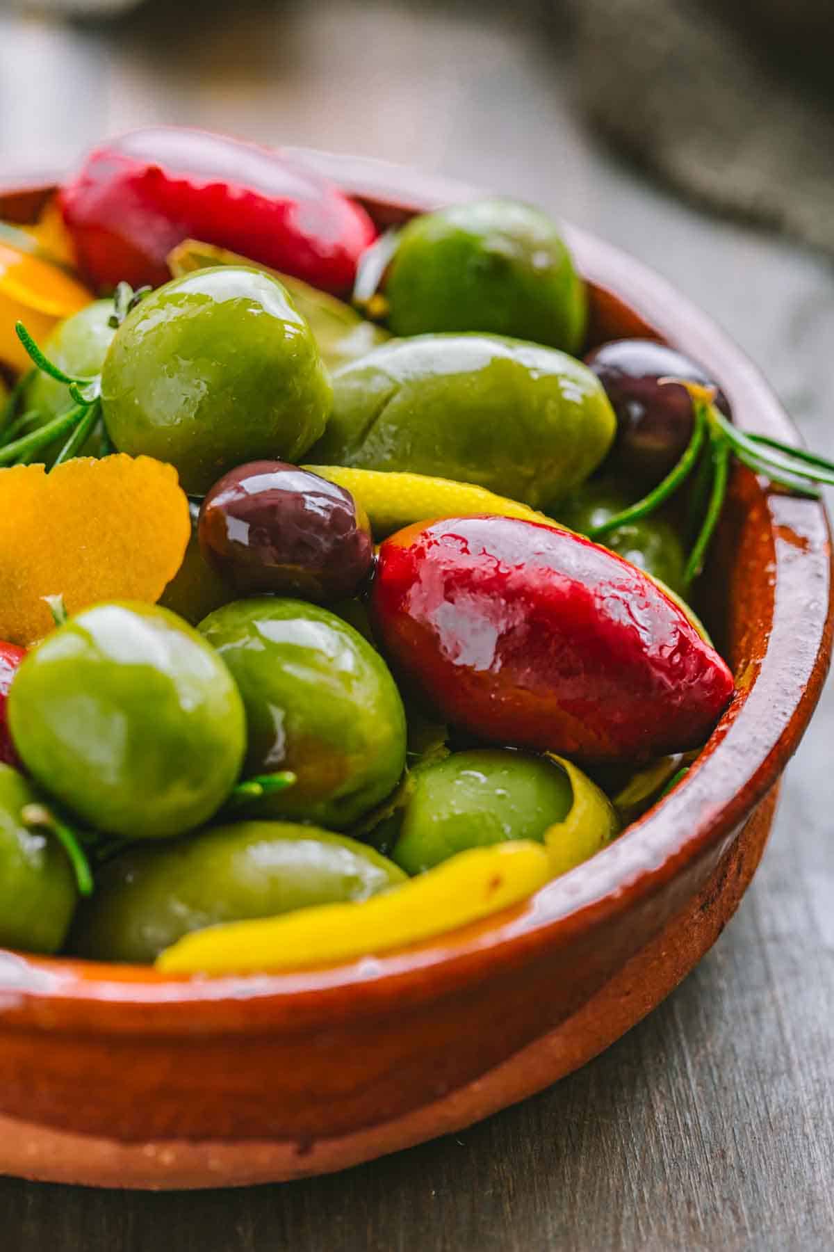 A Spanish style bowl filled with assorted olives.