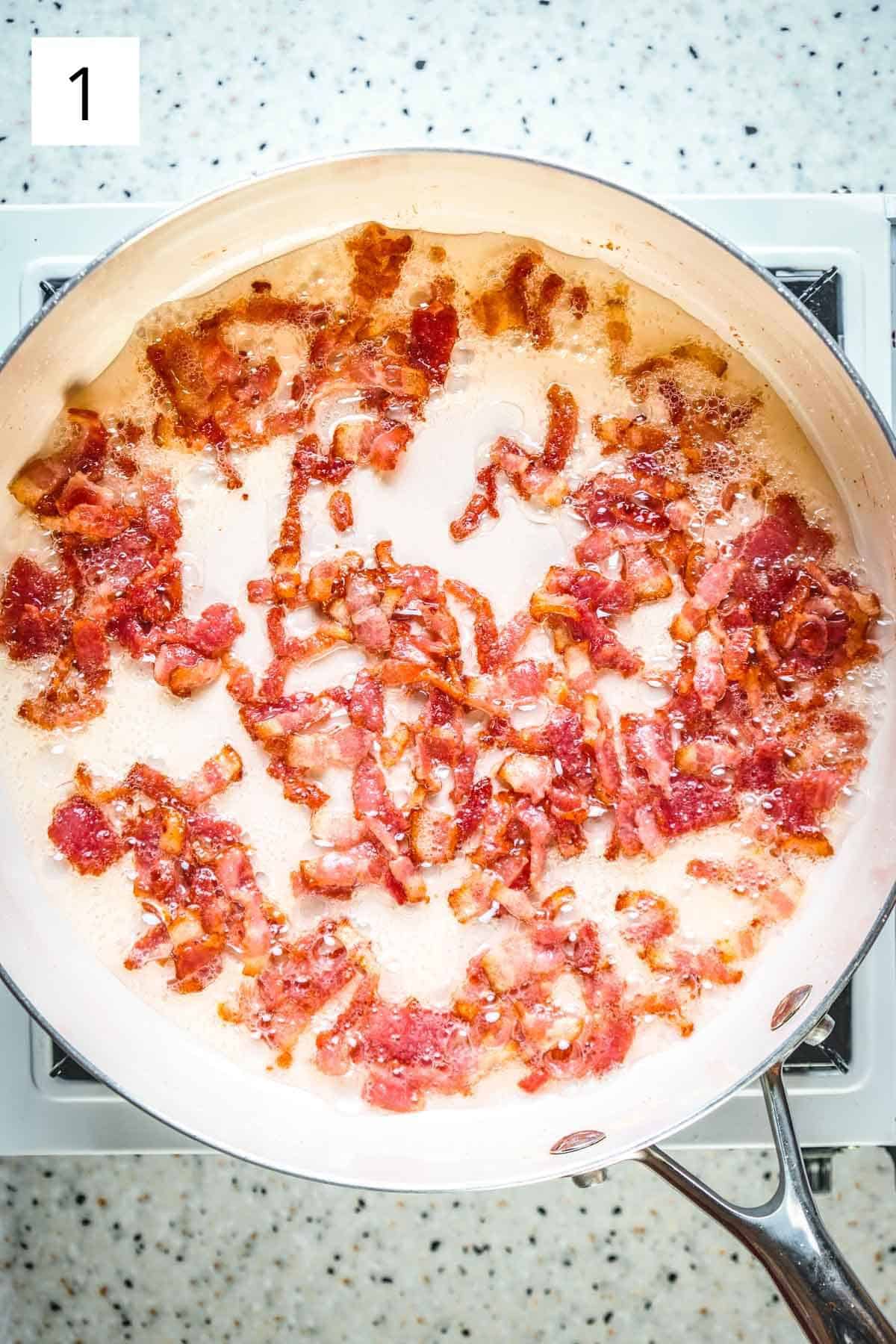 Bacon lardons frying in a pan.