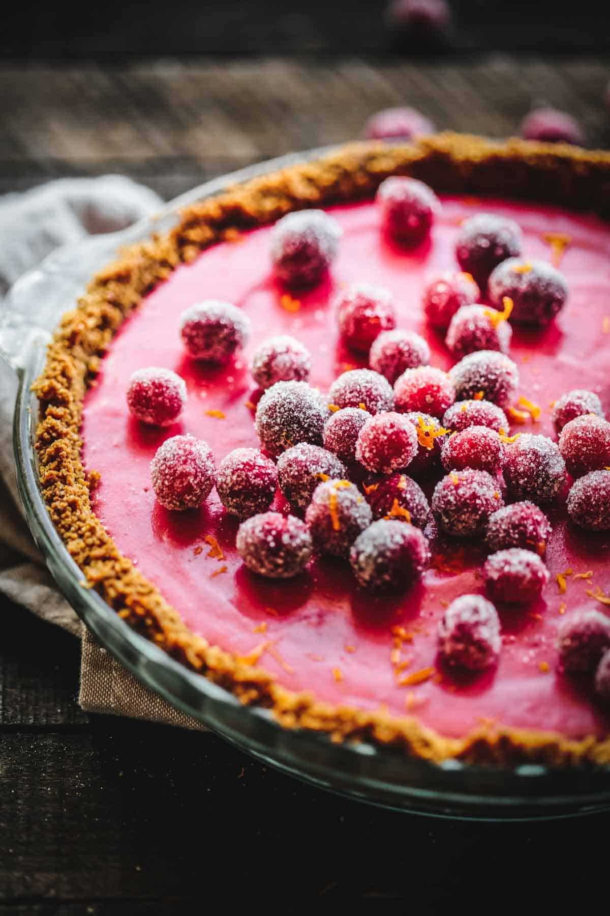 Cranberry curd pie with gingersnap curst and sugared cranberry garnish.