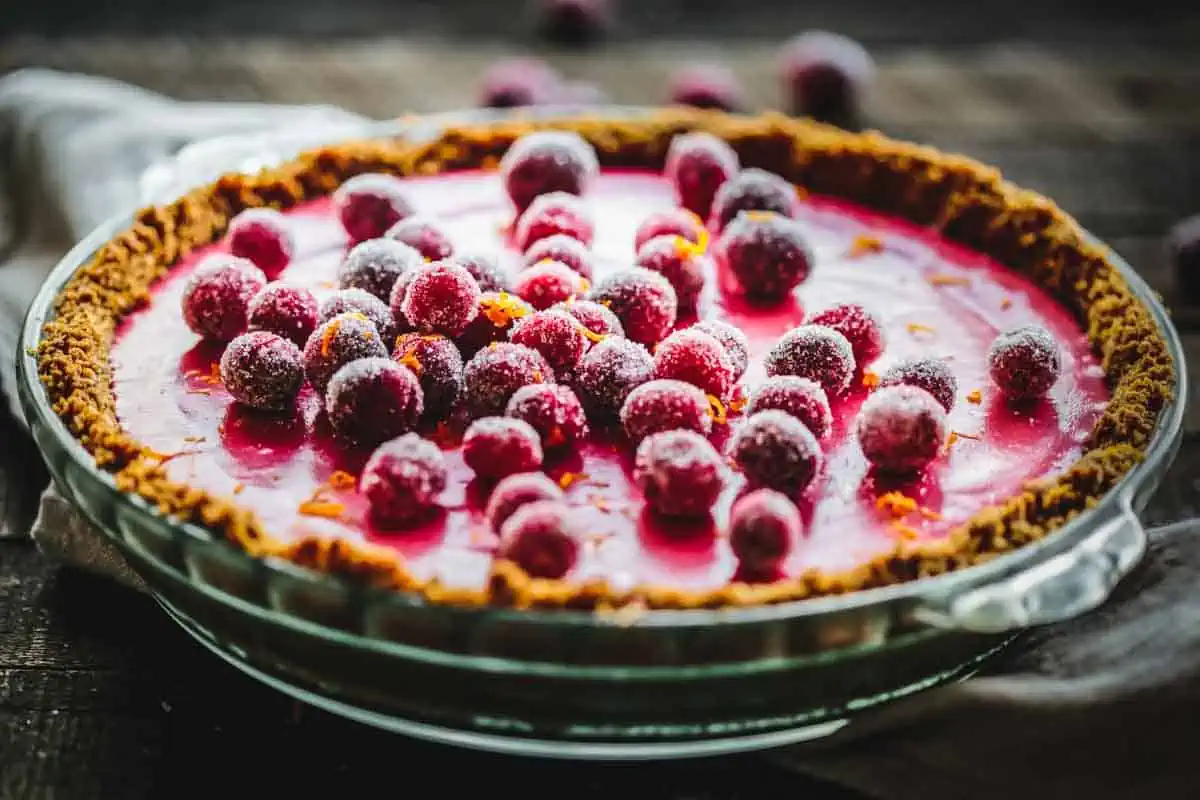 A whole cranberry pie with sugared cranberries on top.