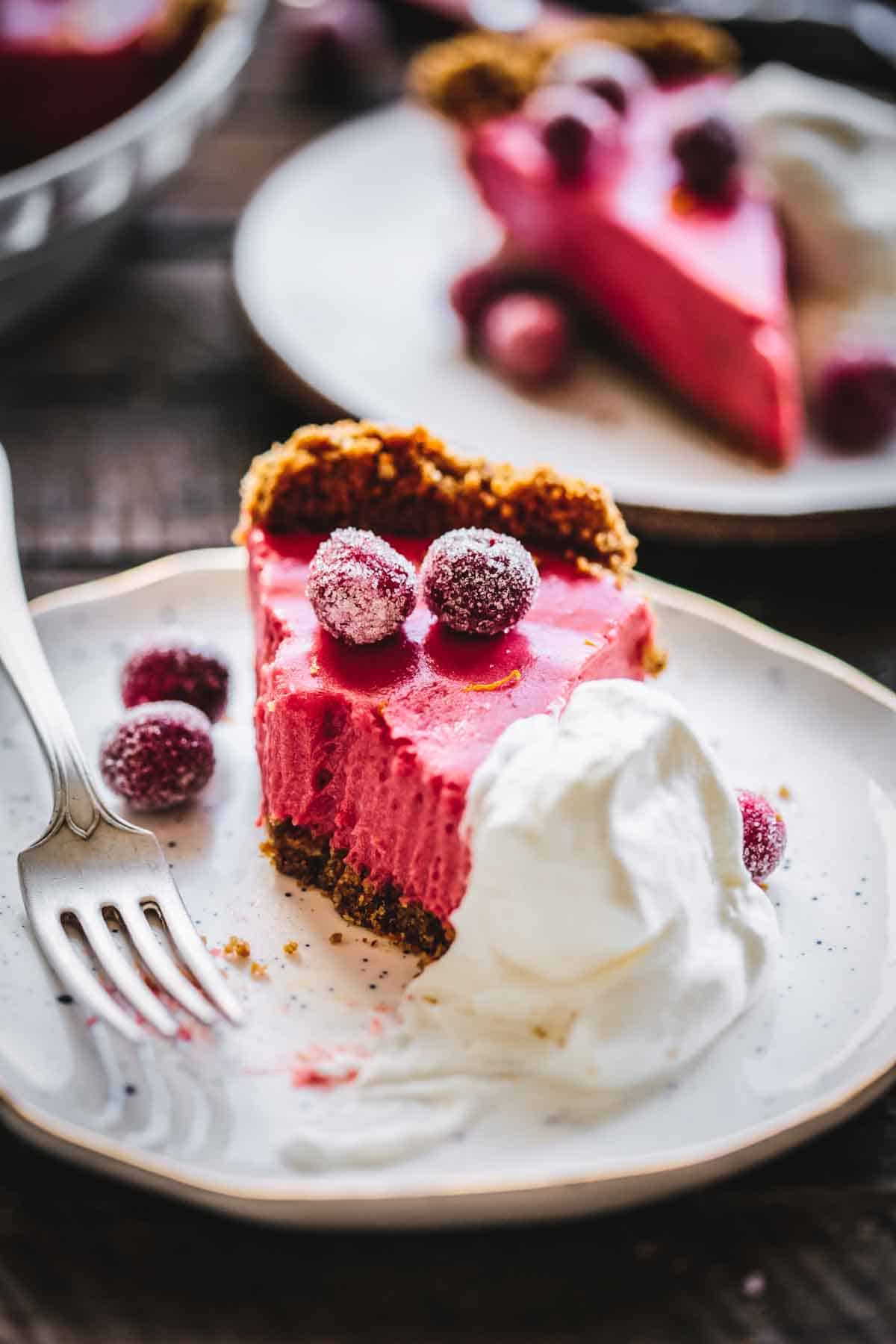 A close up of creamy cranberry pie half eaten with a fork.