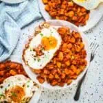 A plate of sweet potato hash with a sunny egg on the side.