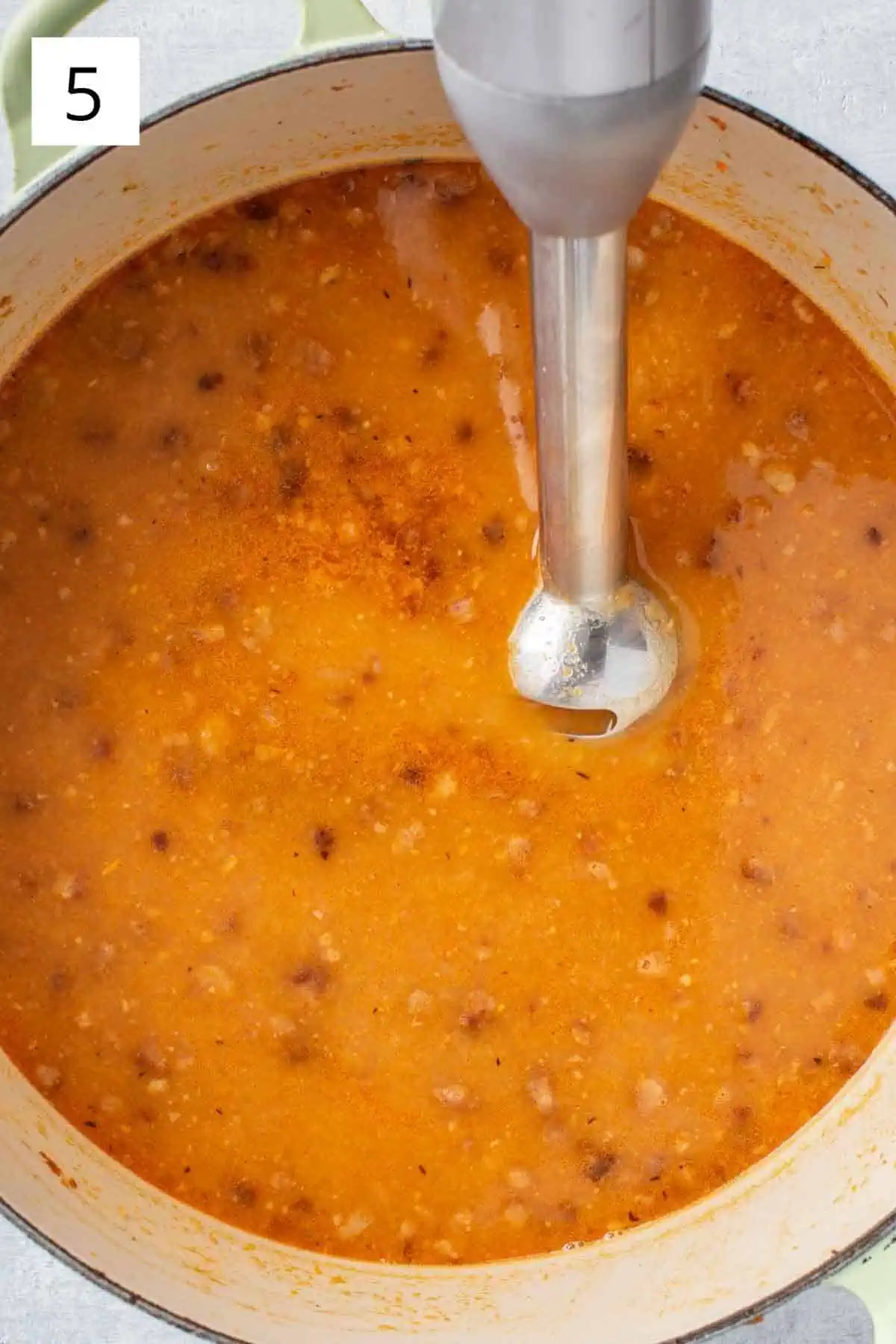 Blending soup in a pot with an immersion blender.