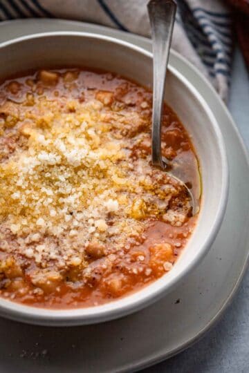 Bowl of Italian soup with a spoon inside.