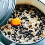 A freshly cooked pot of Caribbean rice and black beans with a scotch bonnet pepper on top.