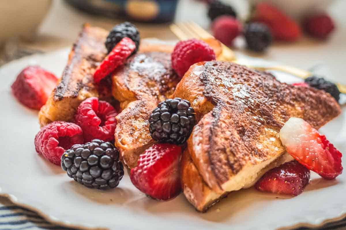 Fresh berries on a plate of mascarpone stuffed French toast.