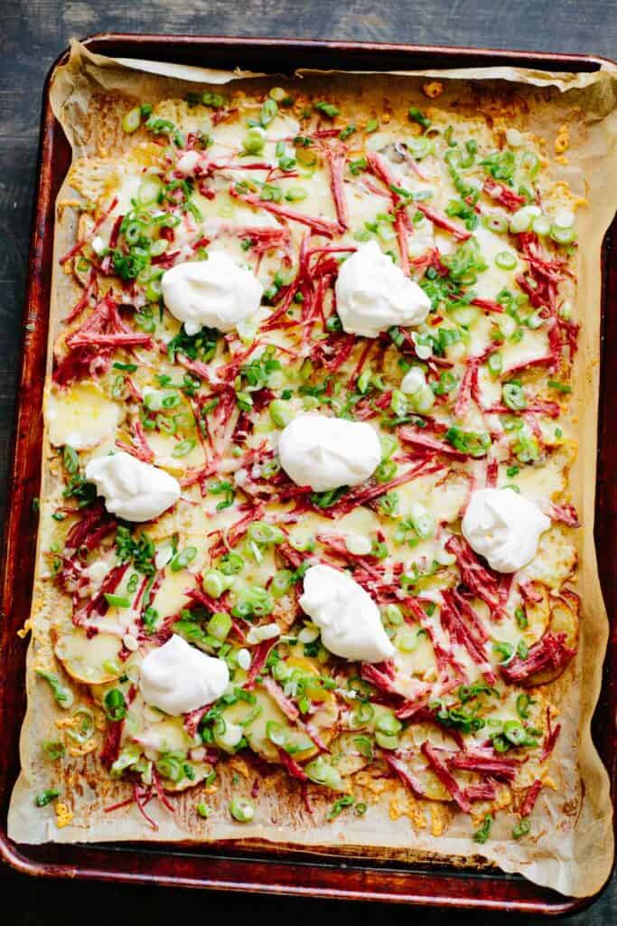 Sheet pan Irish nachos on a parchment-lined baking sheet.