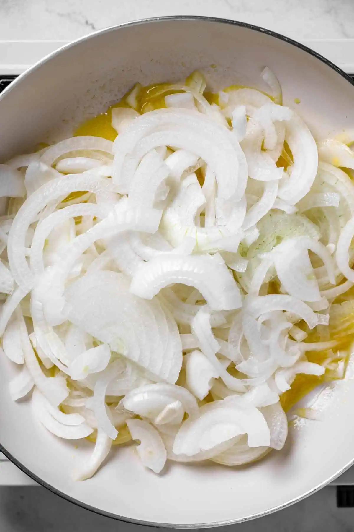 Raw onions in a pan with melted butter.