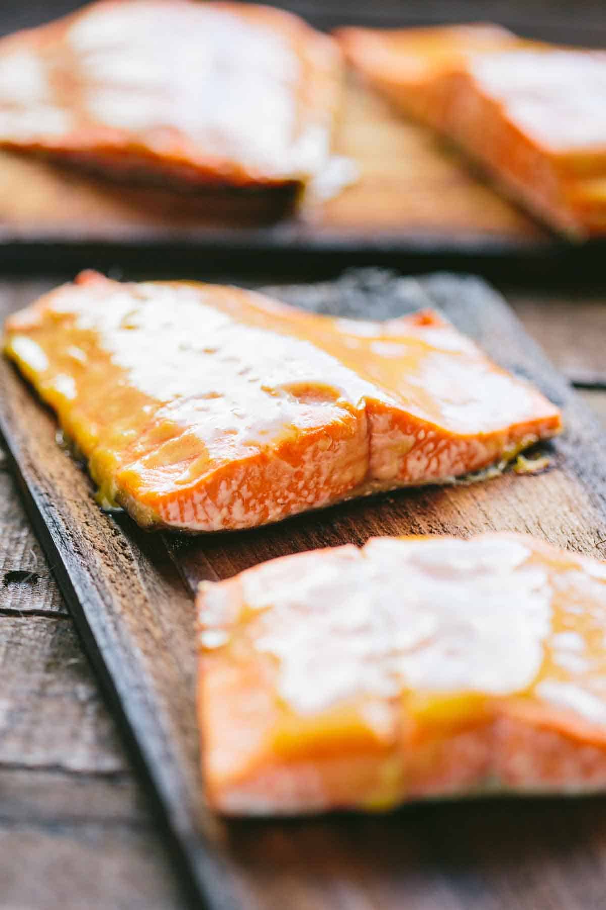 Two salmon fillets cooked on a cedar plank.