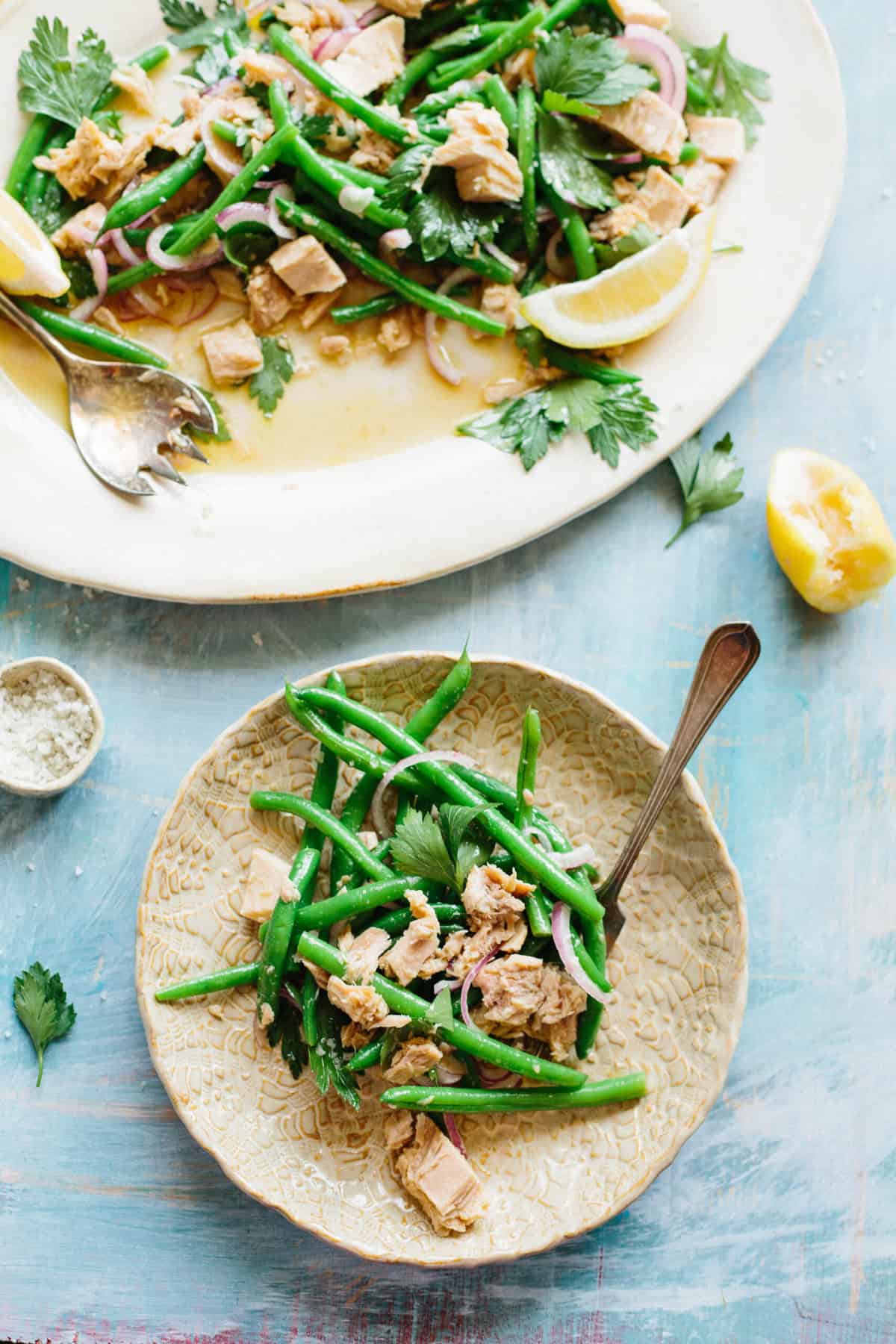 Two plates of Italian tun and green bean salad with lemons and herbs.