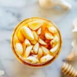 A jar filled with honey and garlic.