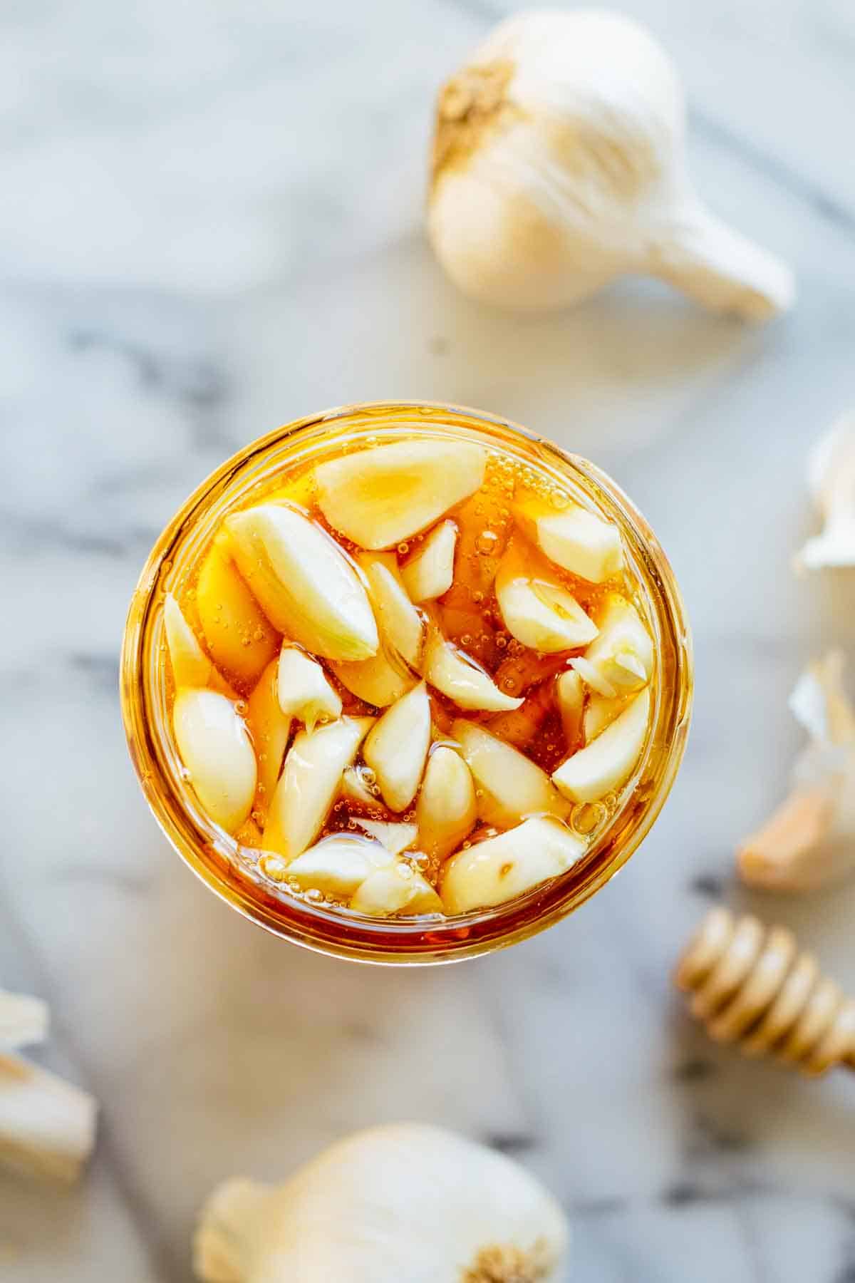 A jar filled with honey and garlic.