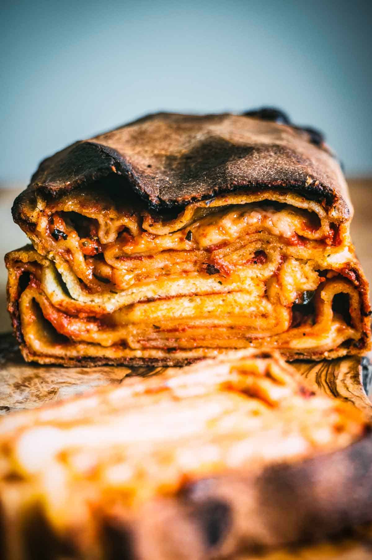 A loaf of local Sicilian bread from Ragusa cut in half to reveal the layers of sauce and cheese.