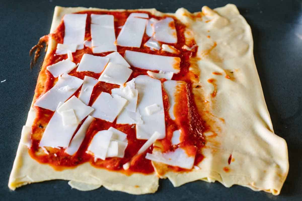 Thinly rolled out dough with tomato sauce and cheese.