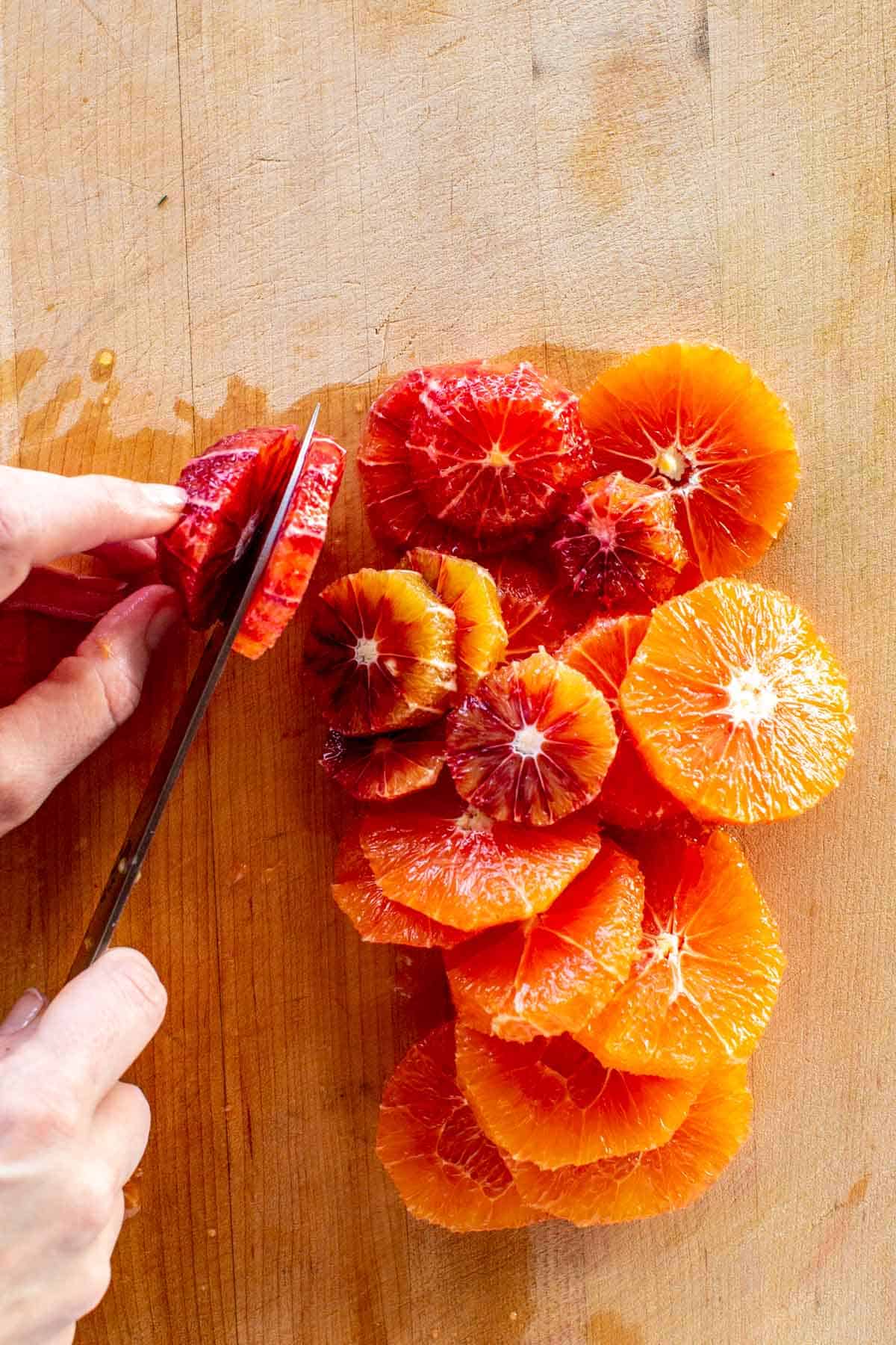 Slicing a blood orange with a knife.